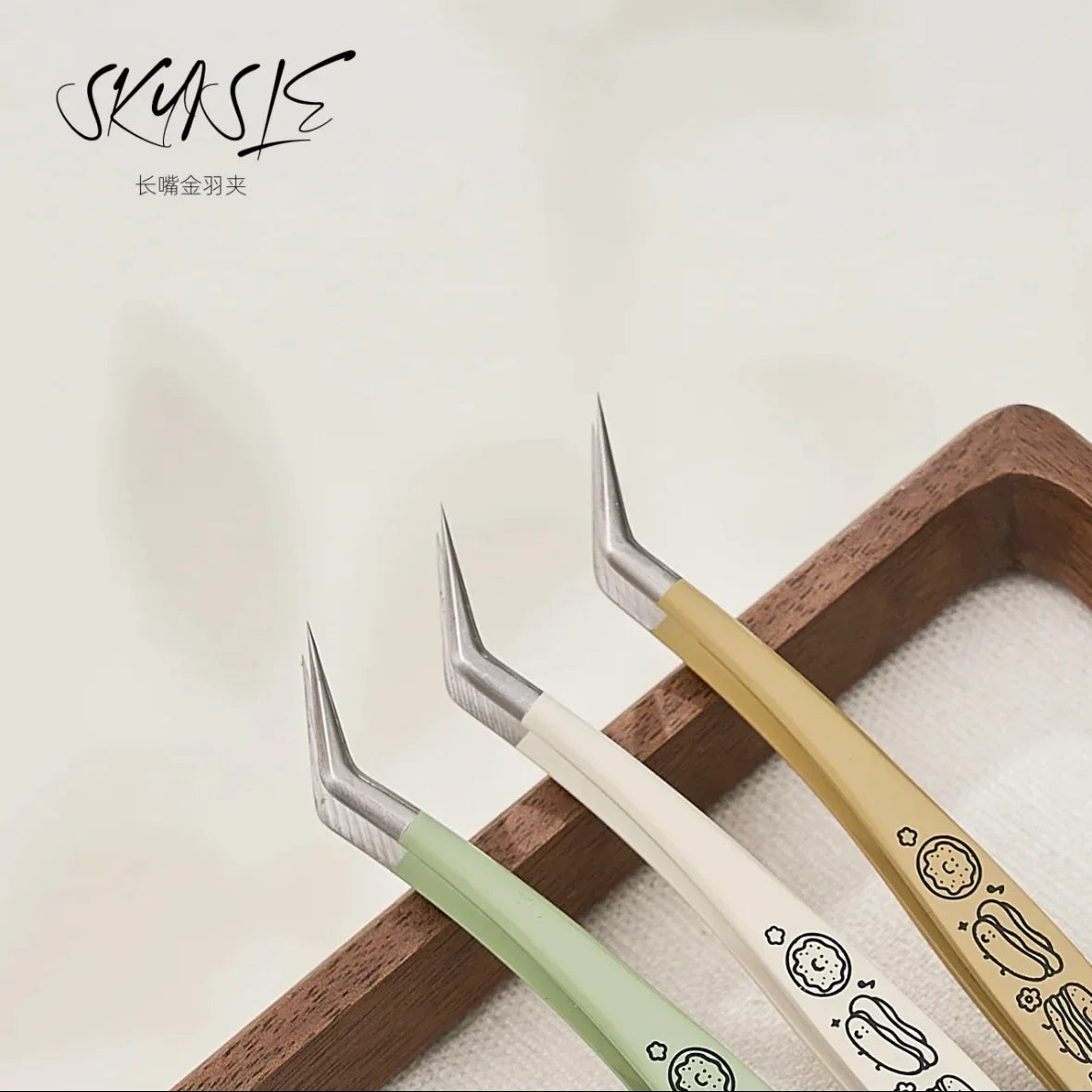 Three fine tip precision tweezers with pastel handles and cute designs for crafting