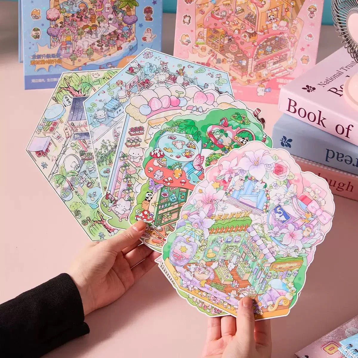 Hand holding colorful, cute town-themed scene stickers for journaling and scrapbooking