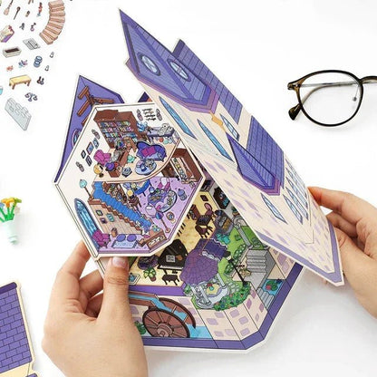 Hands holding a pop-up miniature witch castle scene sticker for journaling or scrapbooking