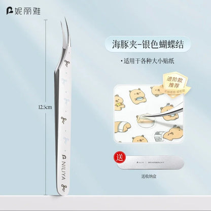 Curved tip tweezers with silver bow pattern, ideal for picking small stickers, shown with cute bear stickers.