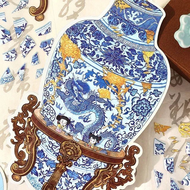 Blue and white porcelain vase sticker with dragon and floral patterns, surrounded by broken ceramic pieces.