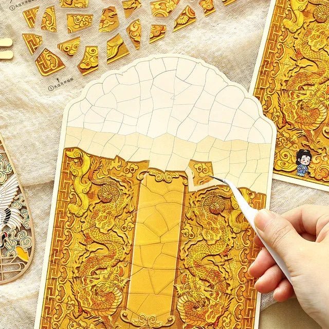 Hand placing dragon-themed gold mosaic sticker piece, DIY journaling craft in progress