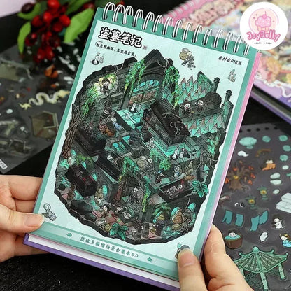Spiral-bound notebook with detailed Xianxia-themed miniature scene sticker sheet, fantasy ruins and characters.