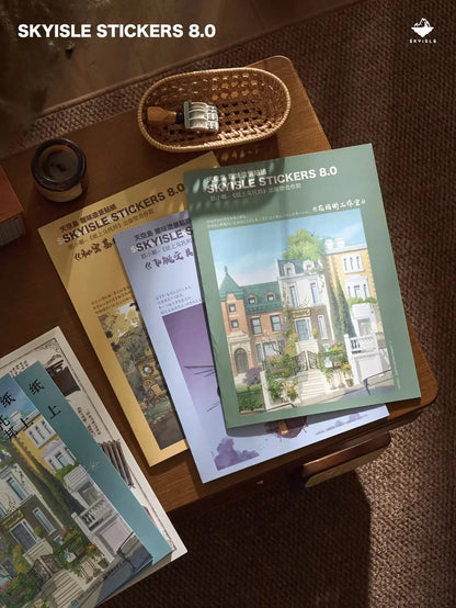 Architect sketch-style sticker sheets with whimsical house designs on a wooden table, cozy stationery setting.